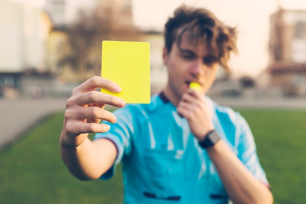 Photo blurred referee showing yellow card