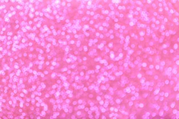 Blurred shiny pink background with sparkling lights.