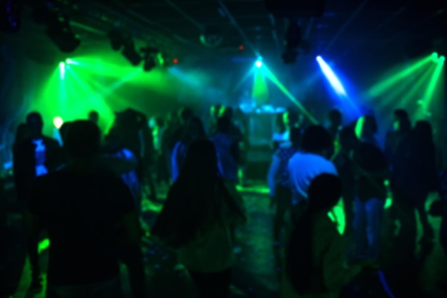 사진 화려한 스포트라이트 아래 댄스 플로어의 나이트클럽에서 춤추는 사람들의 흐릿한 실루엣