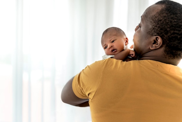 Blurred soft images of baby black skin newborn son is 12dayold on father's shoulder