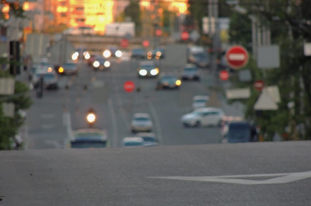 車と道路標識の背景が付いているぼやけた通り