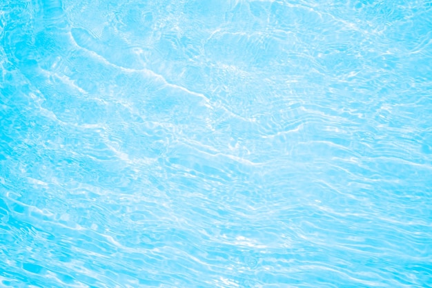 Blurred transparent blue colored clear calm water surface texture with splashes and bubbles Trendy abstract nature background Water waves in sunlight water background