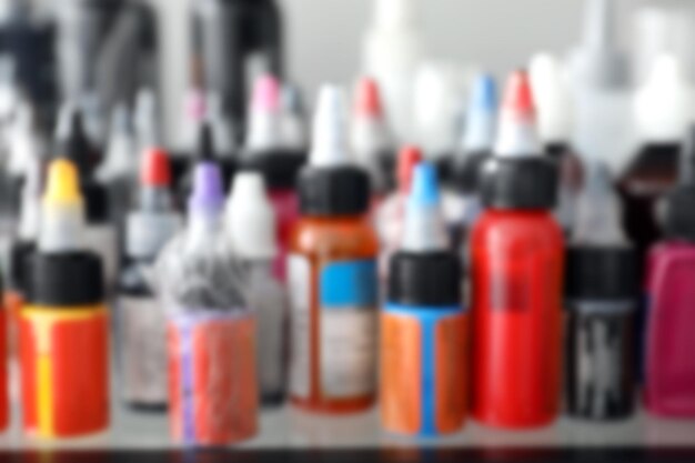 Blurred view of many bottles with ink in tattoo salon