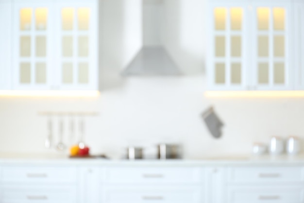 Размытый вид на современный кухонный интерьер с белой мебелью