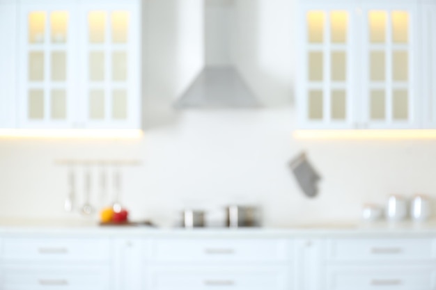 Blurred view of modern kitchen interior with white furniture