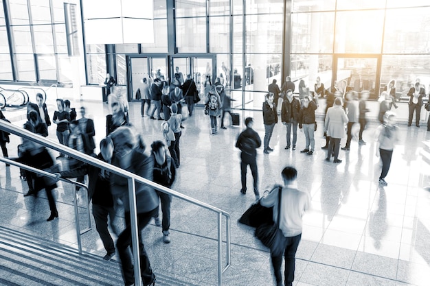 Blurred visitors walking on a entrance at a trade fair hall. ideal for websites and magazines layouts