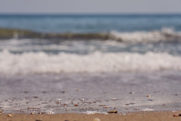 Onde sfocate con schiuma sulla costa del mar egeo a creta grecia.