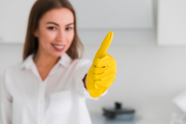 Blurred woman and thumbs up wearing gloves