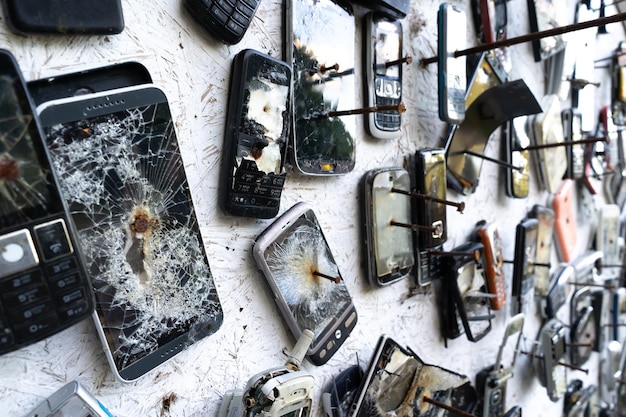 A blurry background of broken phones nailed to the wall