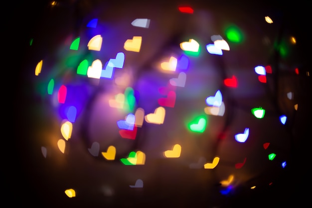 A blurry background with bokeh in the form of hearts in different colors. Defocused background