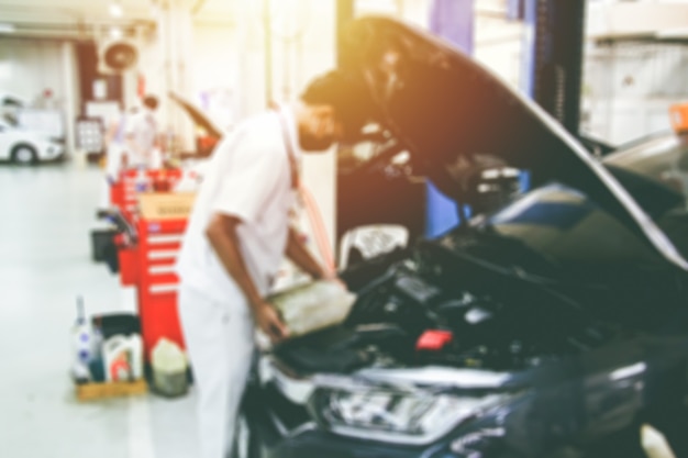 Blurry car repair station and repairman working in the garage
car maintenance concept