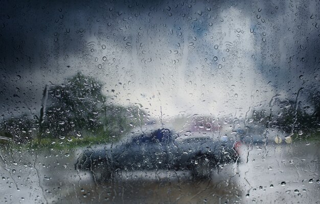 흐릿한 자동차, 비오는 날의 바람막이를 통해 봅니다. 선택적 초점 및 색상 톤.