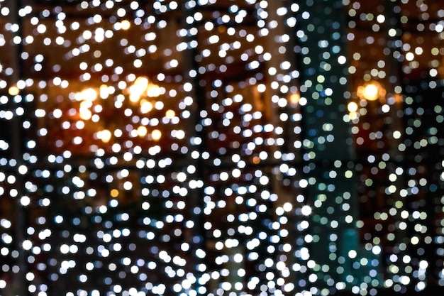 Blurry facade with garlands. Christmas lights in the windows. Bokeh background