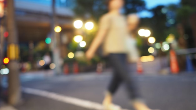 Blurry image of city street life in evening of osaka japan and\
colorful bokeh effect lights.