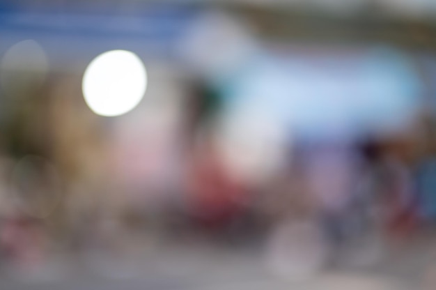 A blurry image of a market with a blue awning.