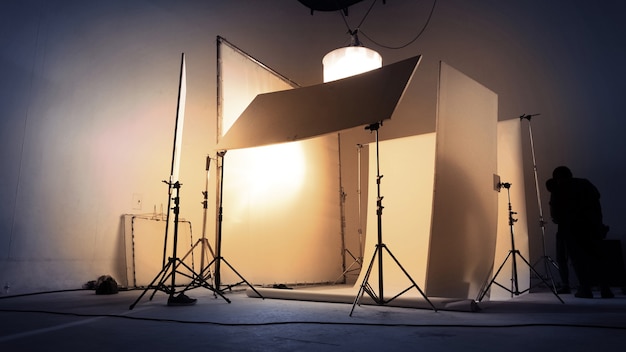 Immagini sfocate del team di produzione vdo che lavora in uno studio fotografico con sfondo e luce