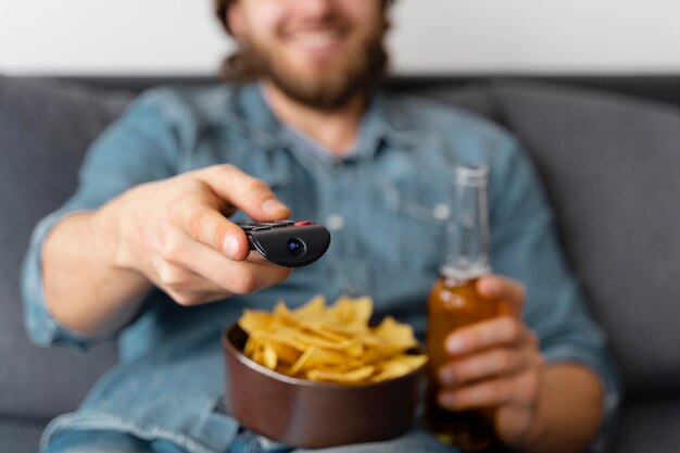 家でテレビを見ているぼやけた男がクローズアップ