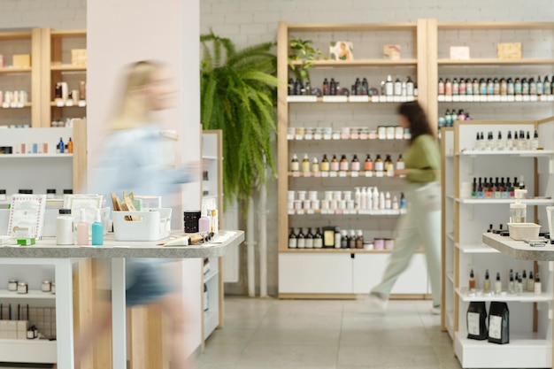 Photo blurry motion of two young women moving along displays with self care items