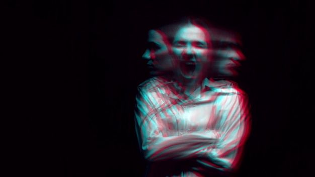 Blurry portrait of a schizophrenic woman with paranoid disorders and bipolar disease on a dark background. Black and white with 3D glitch virtual reality effect