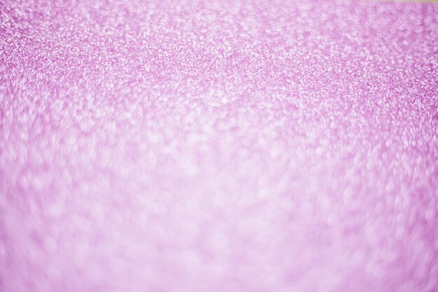 Blurry shimmering background of pink sequins. silver glitter, light abstract bokeh texture. drawing design. sparkling wallpaper for christmas. party time