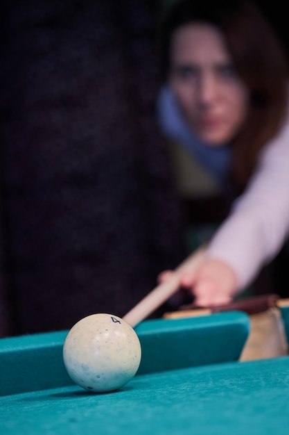 Blurry silhouette of a girl playing billiards