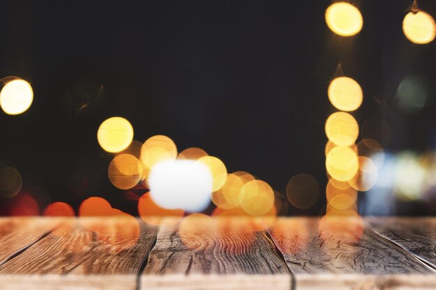 Foto tavolo di legno sfocato con luci bokeh