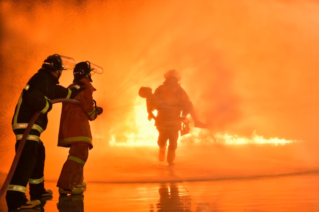 Foto sfocature e sagome di vigili del fuoco che estinguono gli incendi e aiutano le vittime.