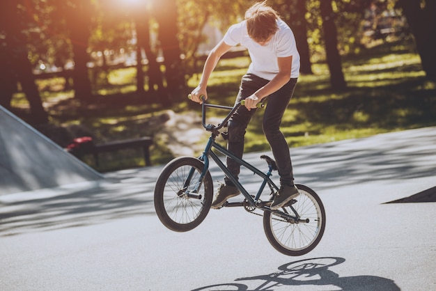 Bmx rider performing tricks at skatepark.