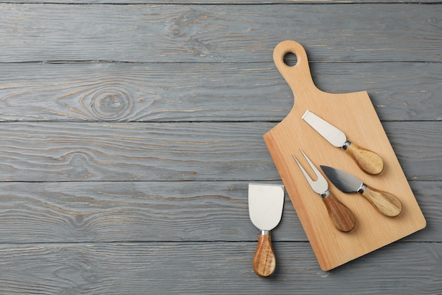 Board and cheese knives on wooden