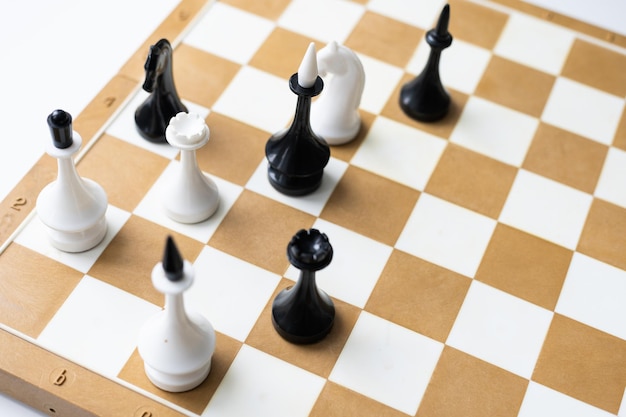 Board game chess with chess pieces in front of white background.