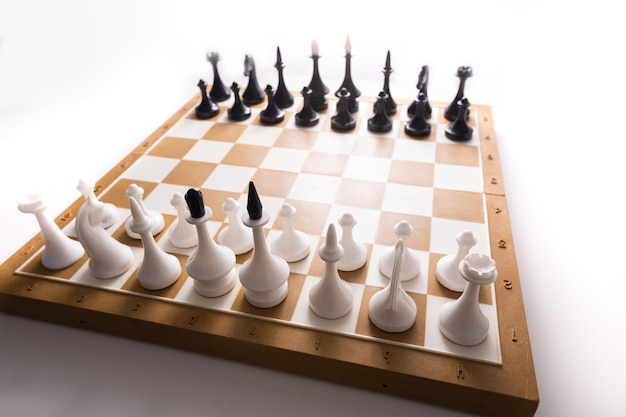 白い背景の前にチェスのピースとボードゲームのチェス。