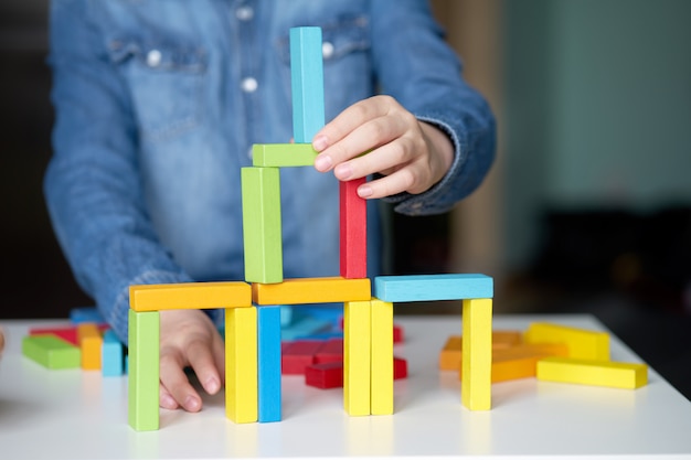 Board game. Child playing with multi-colored wooden cubes.