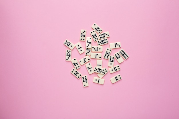 Board game dominoes on pink