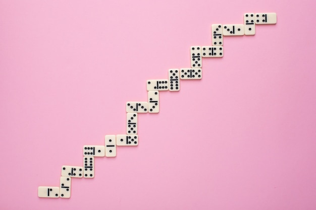 Board game dominoes on a pink