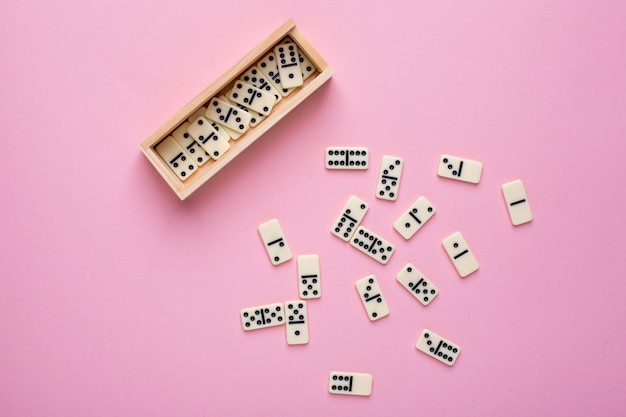 Board game of dominoes on pink