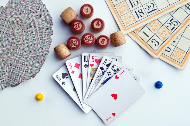 Board games on a light background playing cards bingo bingo cards and chips for board games view from above