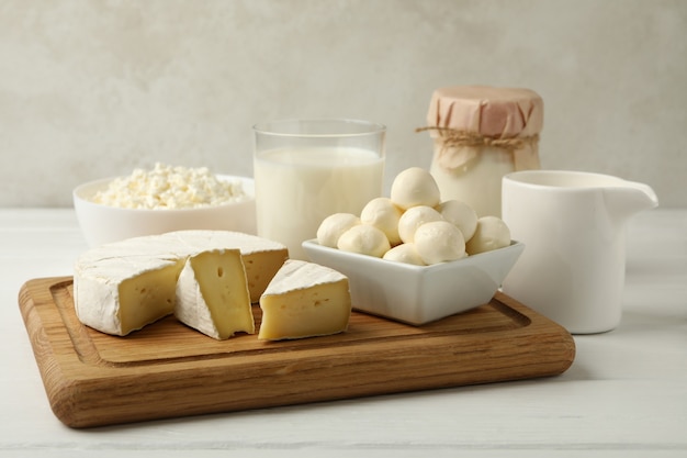 Board with different dairy products on wooden background