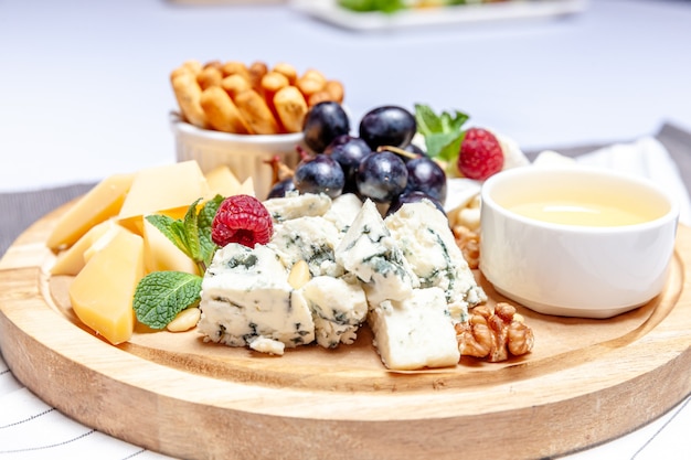 Board with different types of cheese mix set on wooren palte