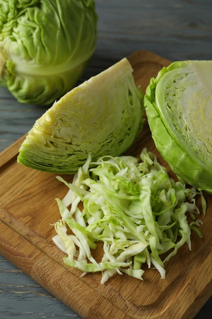 Board with fresh green cabbage on wooden table