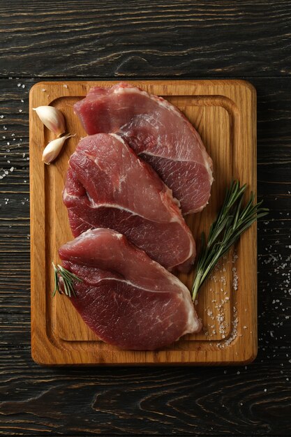 Board with fresh raw steak meat on wooden