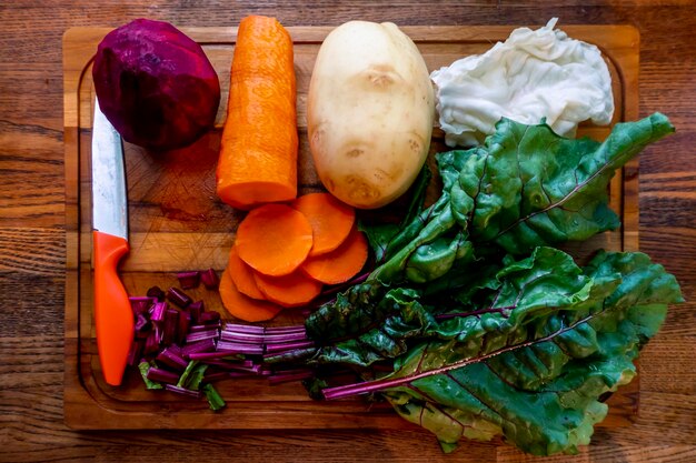 Board with ingredients for preparing tasty borscht on white background