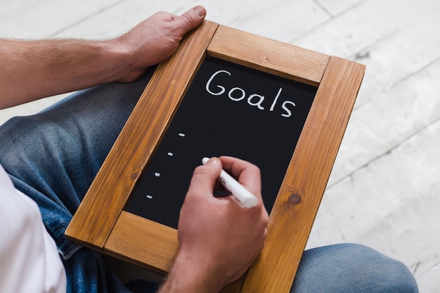 Photo board with new goals. enter new goals. the inscription in chalk on a black chalkboard in a frame of wood.