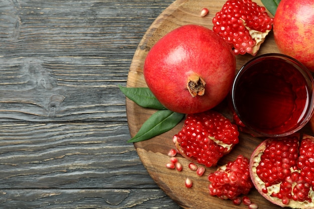 Board with pomegranate juice and ingredients on wooden table