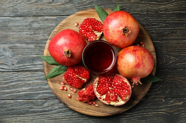 Board with pomegranate juice and ingredients on wooden table