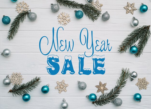 Board with post new year sale, Christmas fir tree with decoration and glitters on wooden background.