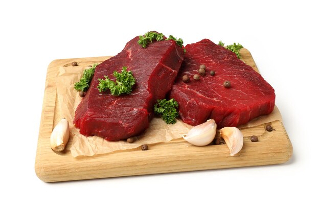 Board with raw beef steaks isolated on white background