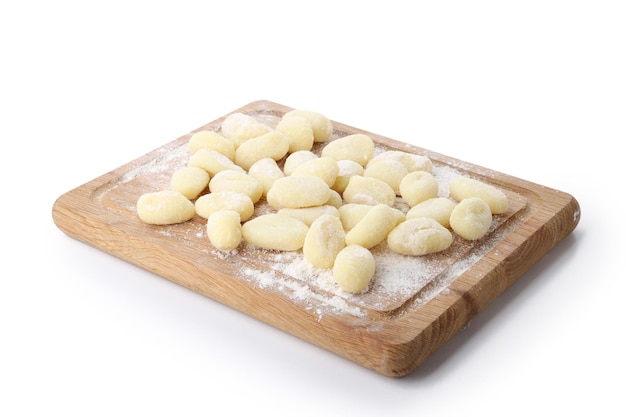 Board with raw potato gnocchi isolated on white background