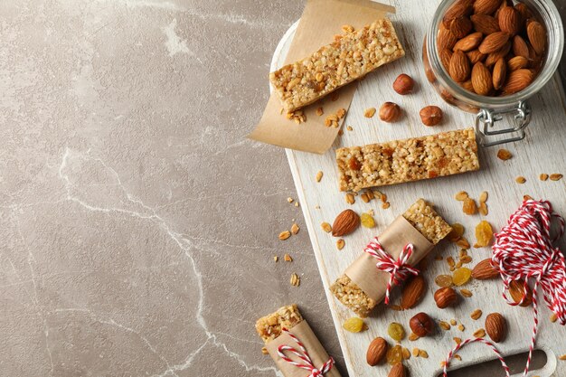 Pensione con gustose barrette di cereali e noci su sfondo grigio, vista dall'alto