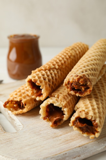 Board with wafer rolls with condensed milk, close up