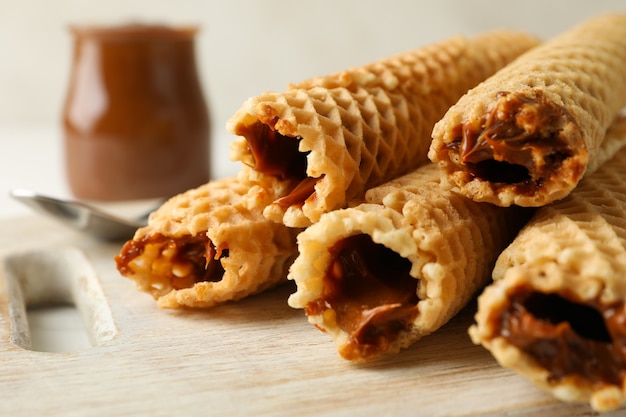 Board with wafer rolls with condensed milk, close up